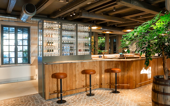 Bar area with stools and glassware display inside Home of Carlsberg exhibit.