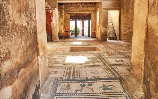 Ancient mosaic floor in a preserved room at Pompeii, Italy.