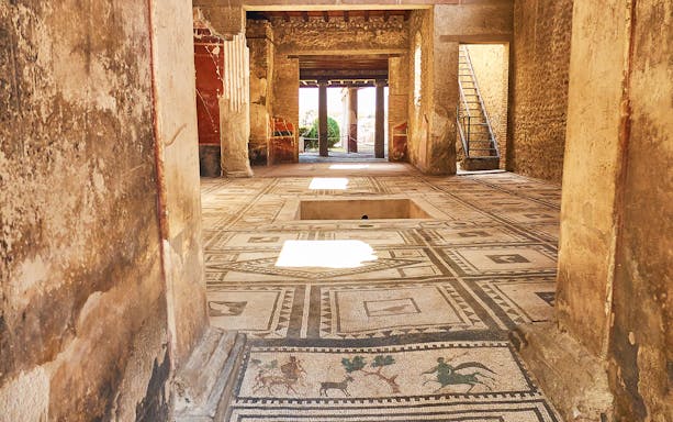 Ancient mosaic floor in a preserved room at Pompeii, Italy.