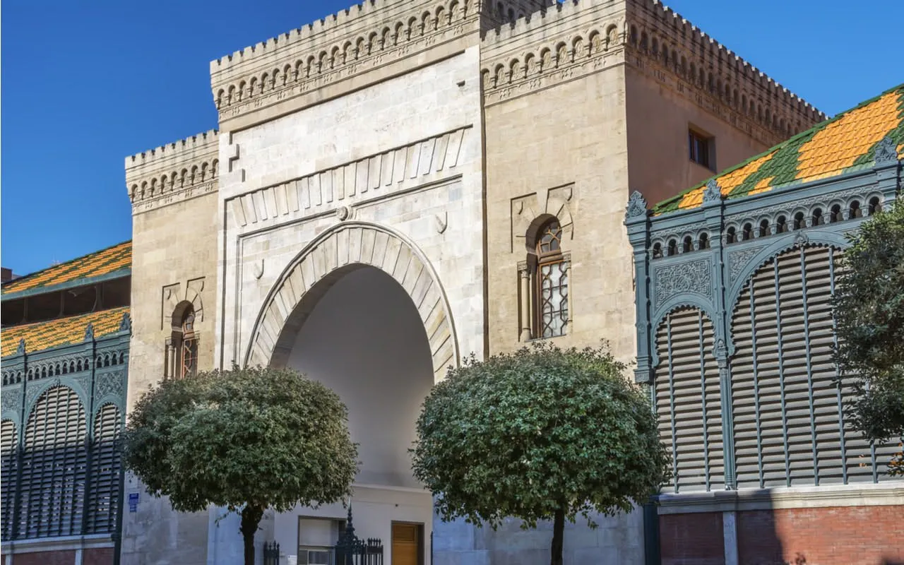 Malaga Atarazanas Market entrance with ornate arch and trees.