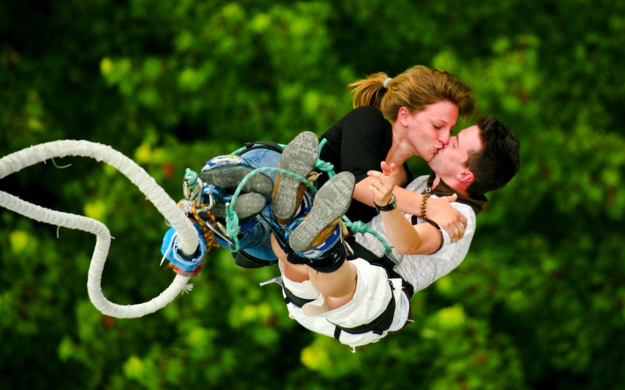 Couple bungee jumping and kissing at Skypark Sentosa by AJ Hackett.