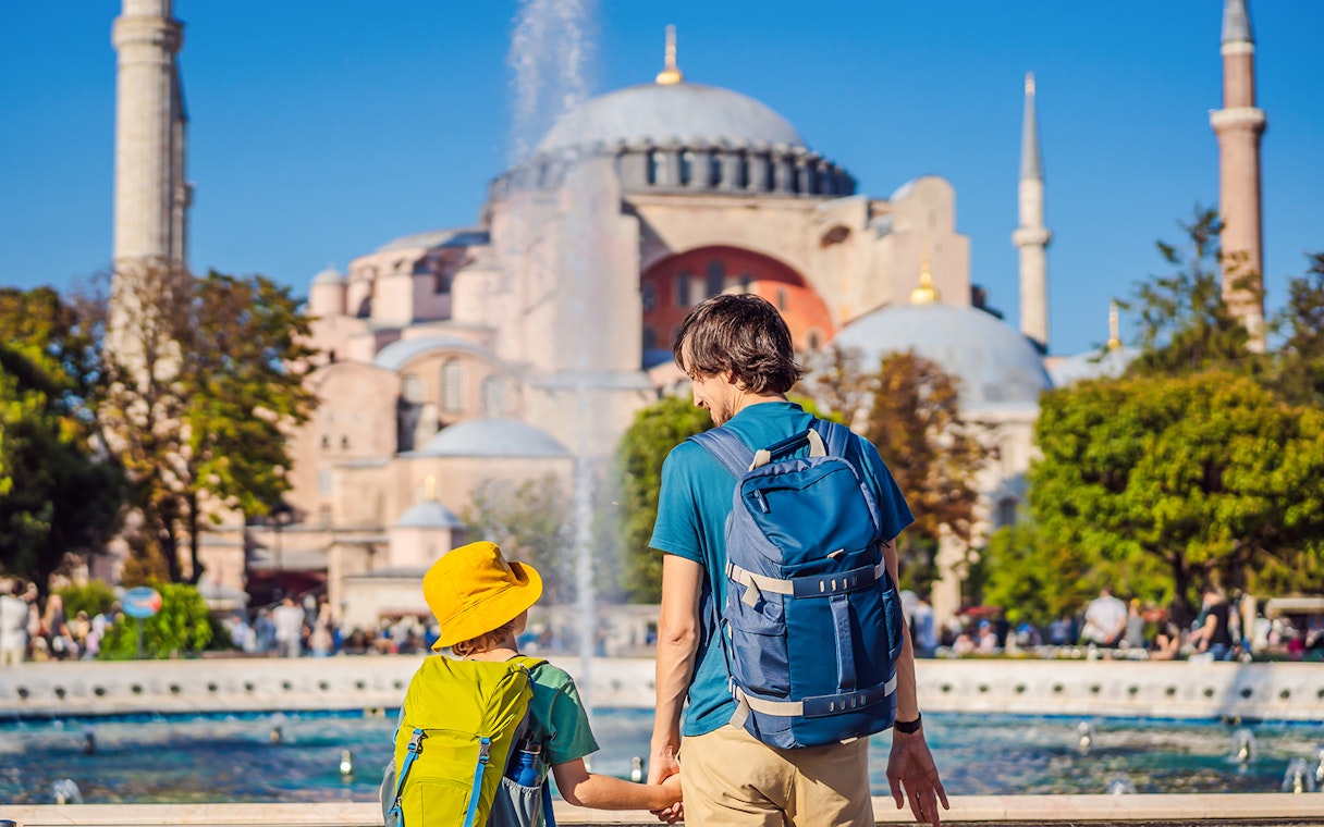 Father and son holding hands in Hagia Sophia gardens, Istanbul.