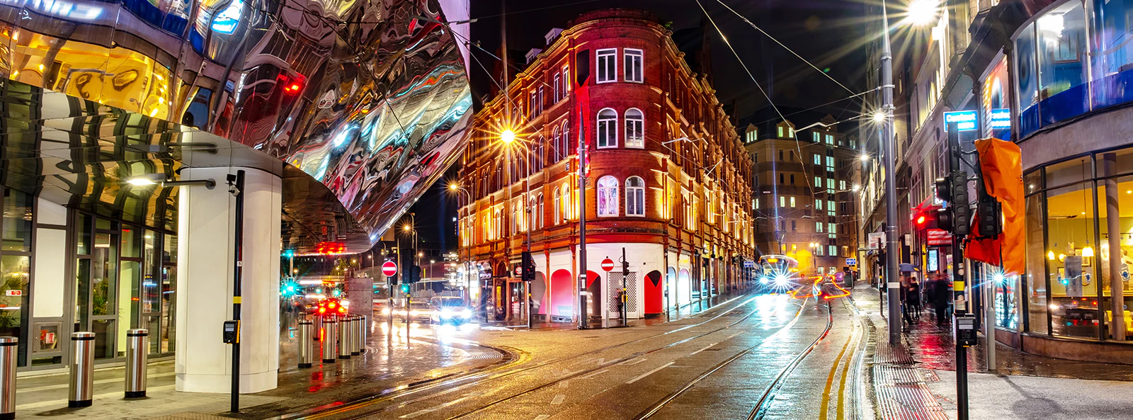 Birmingham city center nightlife with illuminated streets and bustling crowds.