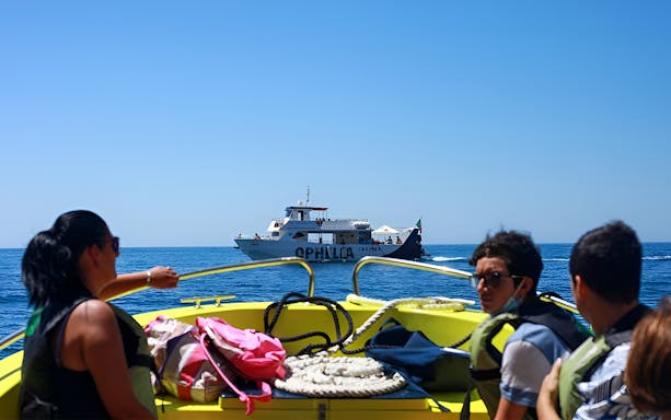 Catamaran cruise with passengers approaching Benagil Caves from Portimão.