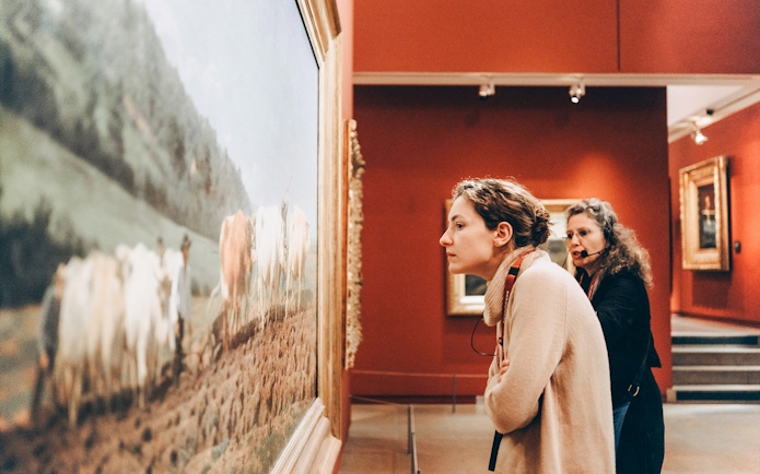 Woman observing painting at Orsay Museum, Paris.