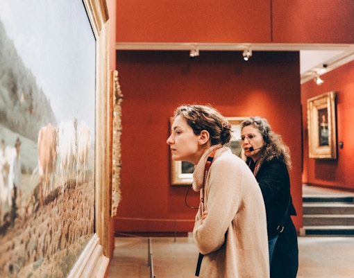 Woman observing painting at Orsay Museum, Paris, France.