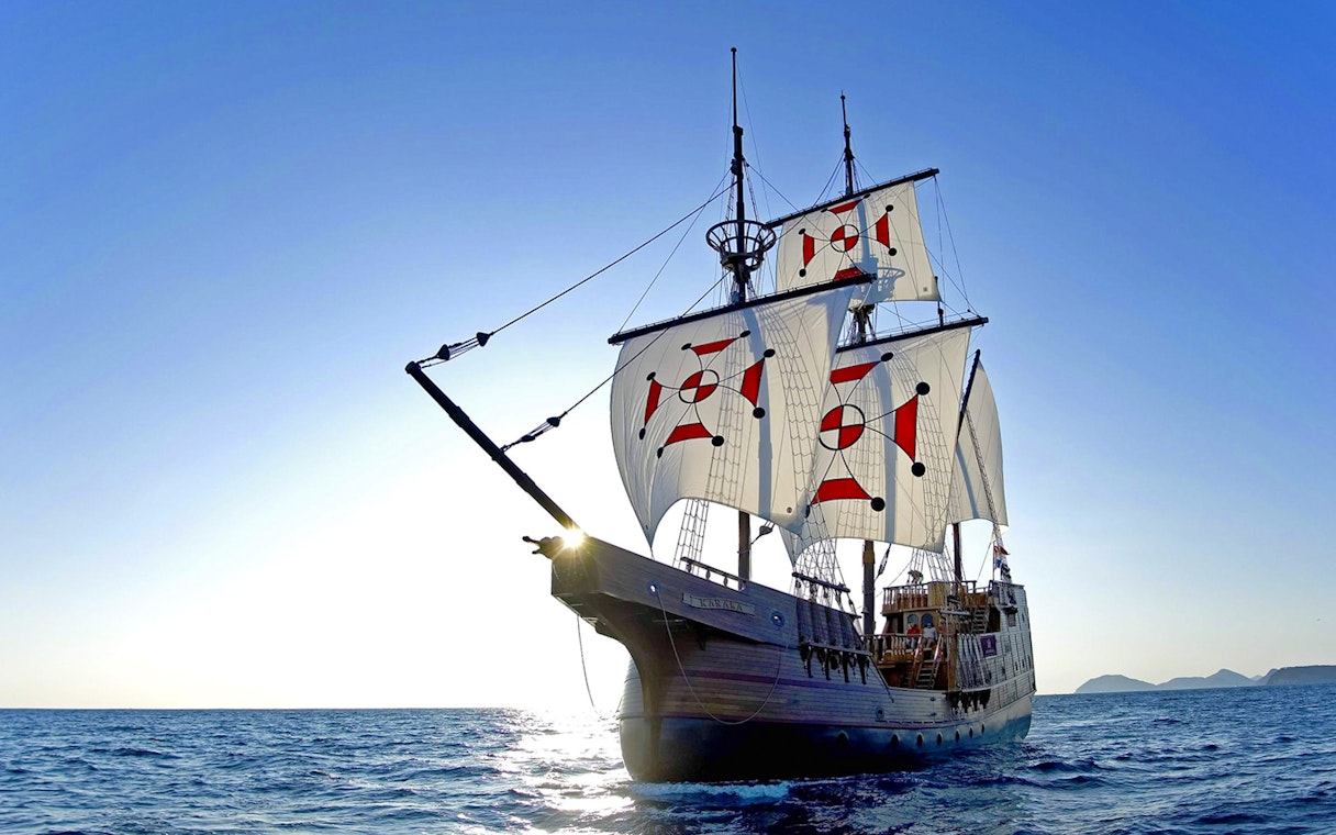 Sailing ship on Elaphite Islands cruise under clear blue sky.