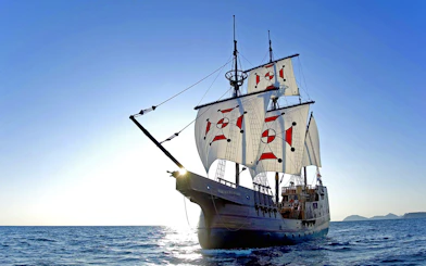 Sailing ship on Elaphite Islands cruise under clear blue sky.