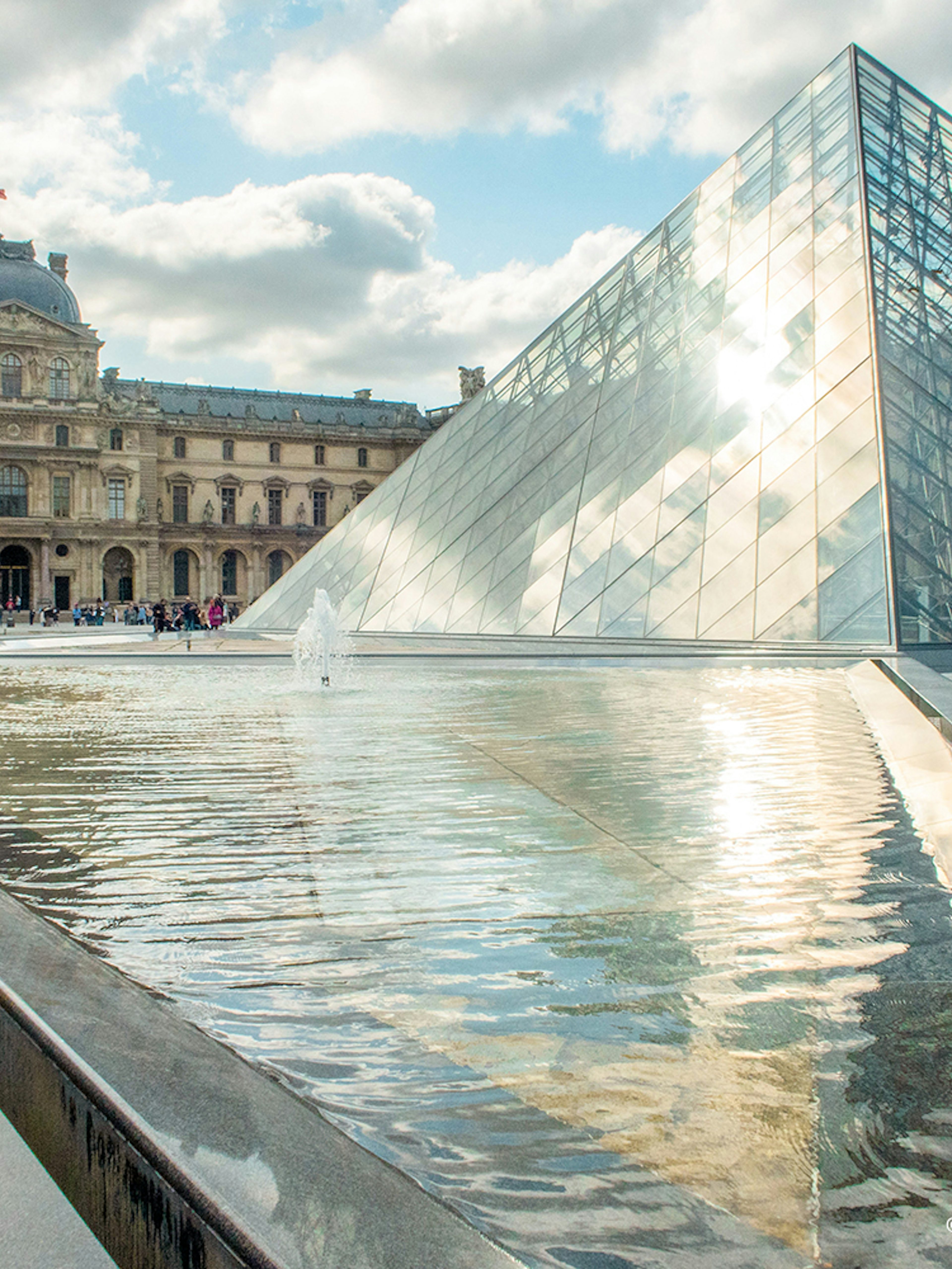 Louvre Museum glass pyramid and courtyard in Paris, France.