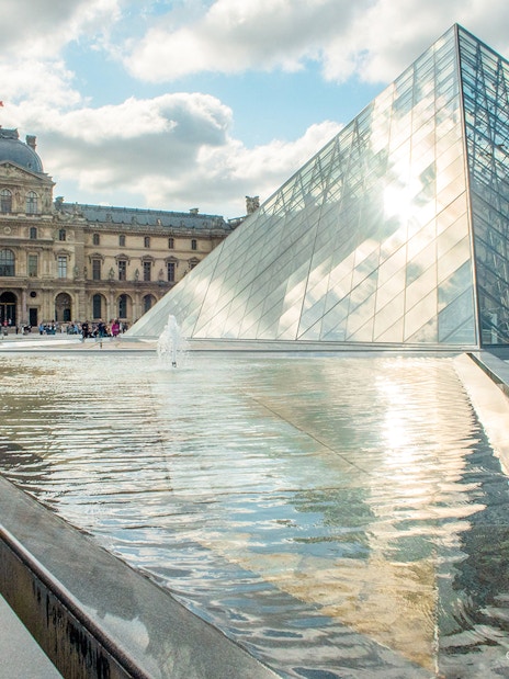 Louvre Museum glass pyramid and courtyard in Paris, France.