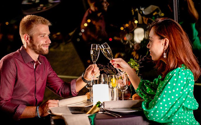 Couple toasting with champagne on Seine dinner cruise at 8:30pm.