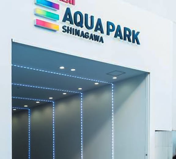 Entrance to Maxell Aqua Park Shinagawa with illuminated signage.