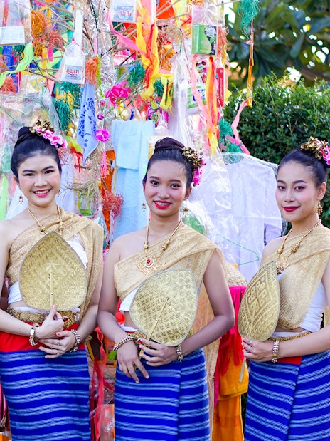 Thai women in traditional dress with fans at Yi Peng and Loy Krathong Festival 2025, Chiang Mai.