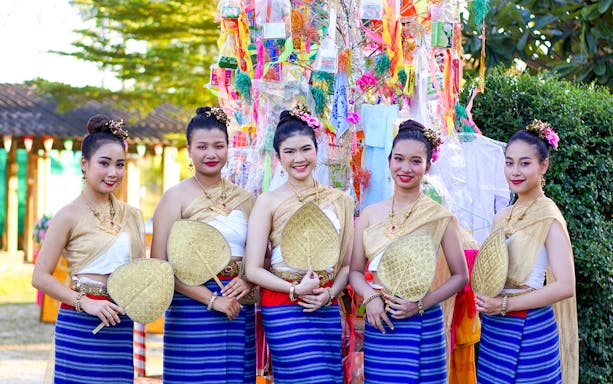 Thai women in traditional dress with fans at Yi Peng and Loy Krathong Festival 2025, Chiang Mai.