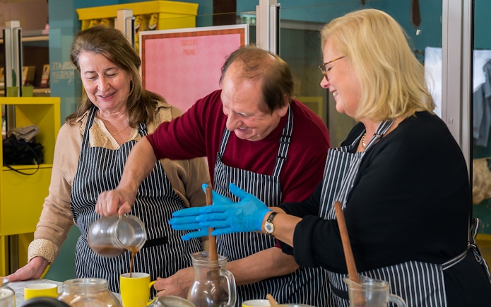 Chocolate workshop participants pouring chocolate at Vienna museum.
