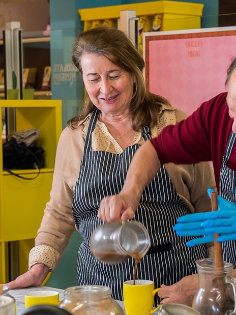 Chocolate workshop participants pouring chocolate at Vienna museum.