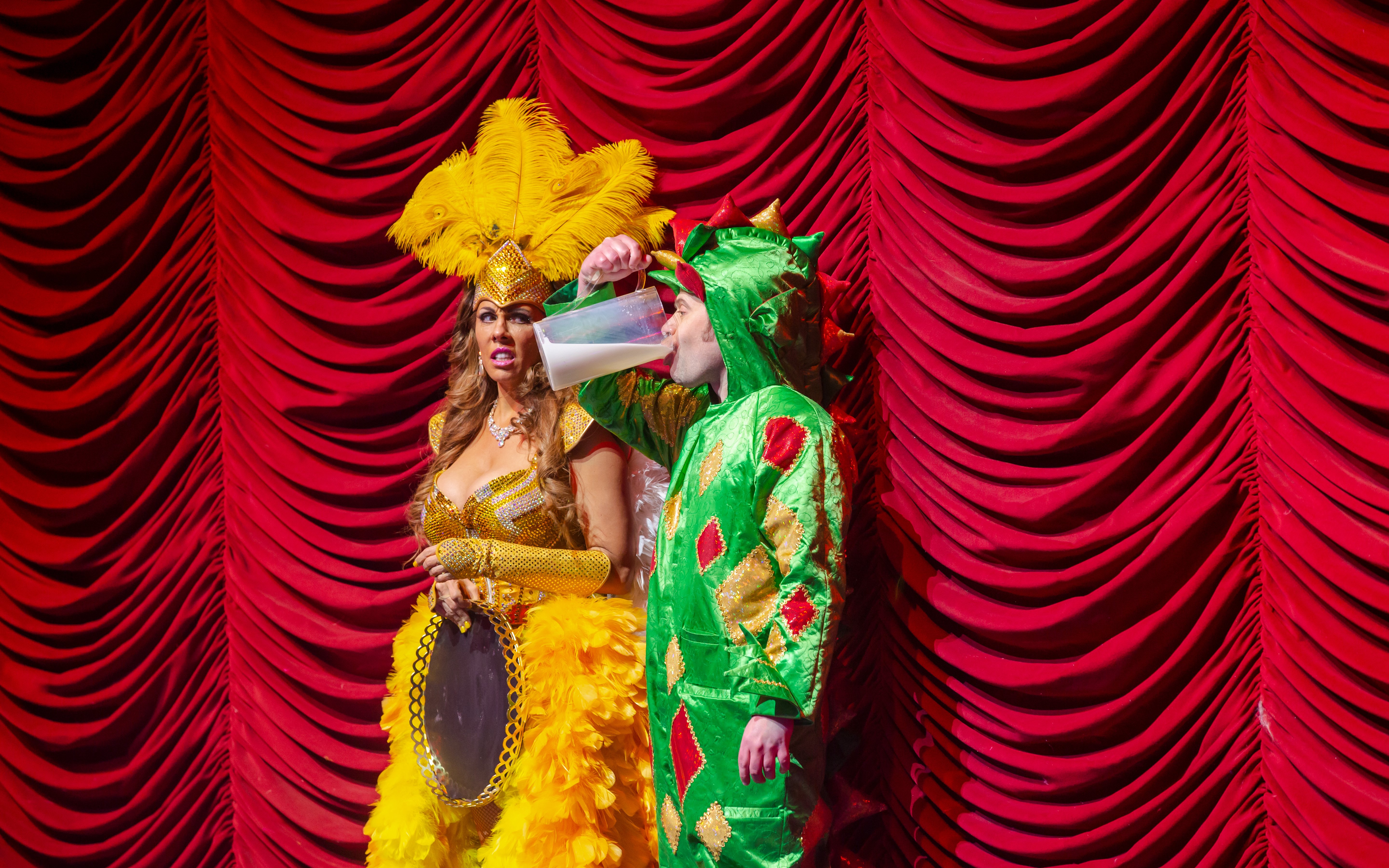 Performer in dragon costume drinking on stage at Piff the Magic Dragon show, Vegas.