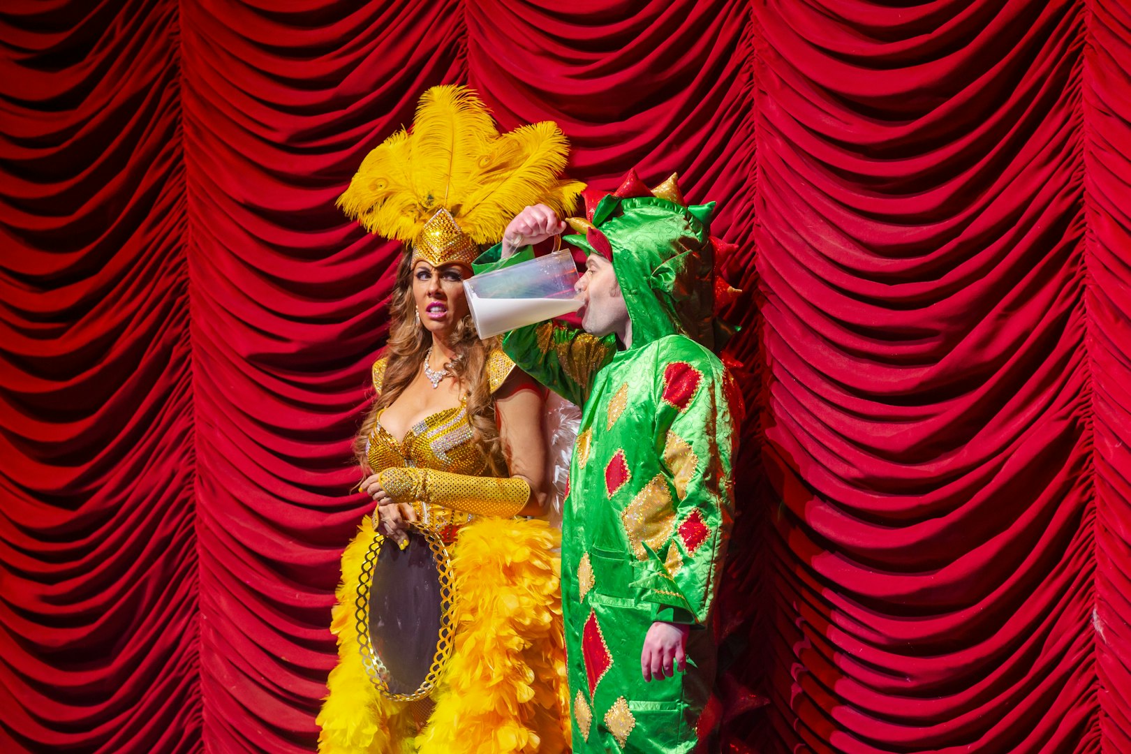 Performer in dragon costume drinking on stage at Piff the Magic Dragon show, Vegas.
