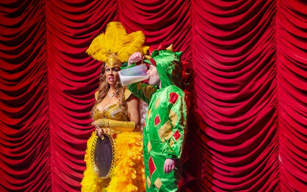 Performer in dragon costume drinking on stage at Piff the Magic Dragon show, Vegas.