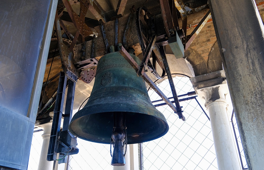 St Mark's Campanile bell tower in Venice, Italy, with blue sky background.