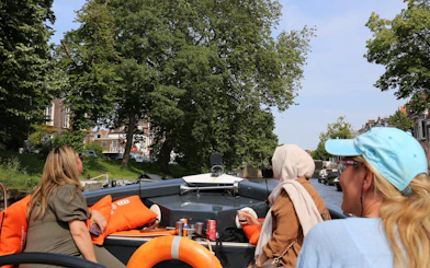 Open-boat canal cruise in Haarlem with passengers enjoying live skipper commentary.