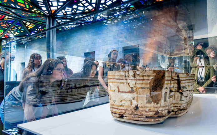 Visitors observing ancient artifact at National Gallery of Victoria during Best of NGV Experiences Tour.