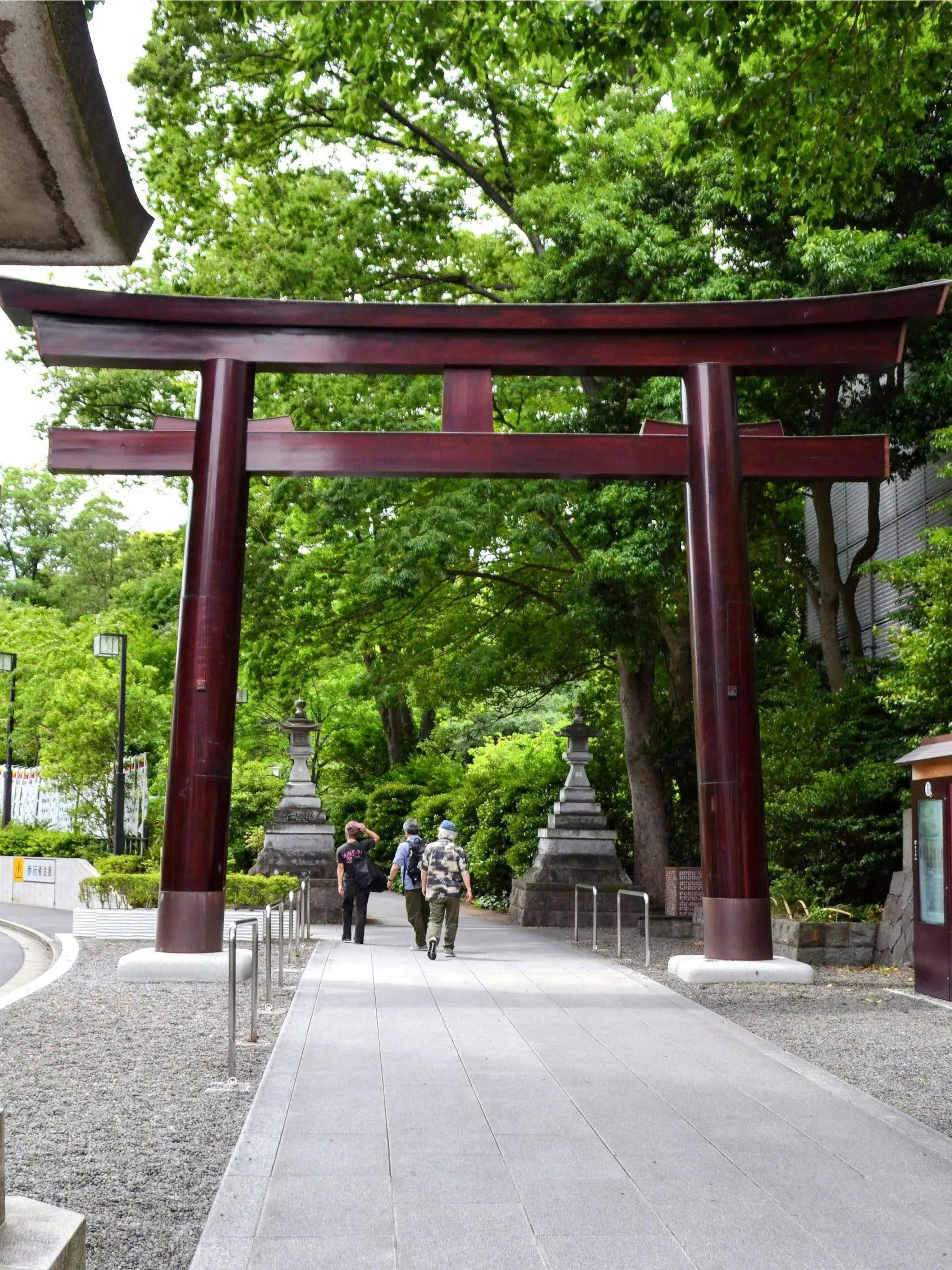 Traditional Torii gate at a hidden shrine near Takeshita Street, Tokyo, surrounded by greenery.