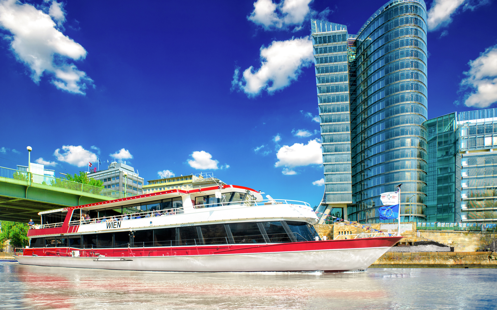 MS Wien ship on Danube Canal, Vienna, with UNIQA Tower in background.
