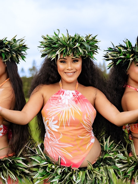 Dancers performing at Mauka Warriors Luau in traditional attire with greenery backdrop.