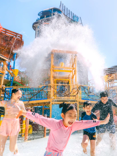 Children playing under a water splash at Vana Nava Water Jungle, Hua Hin.
