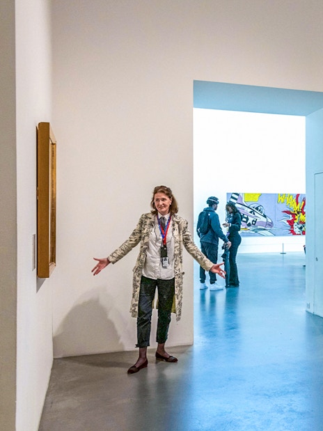 Guide explaining artwork to visitors inside Tate Modern.