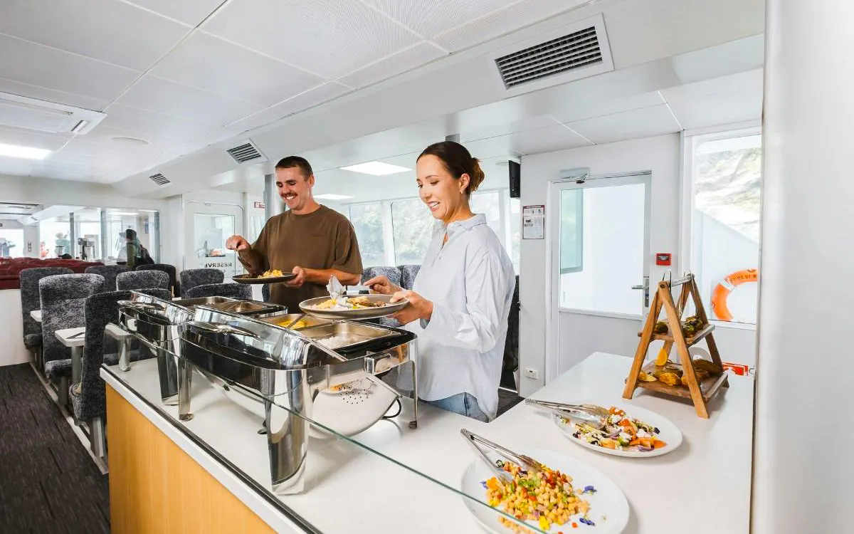 Couple enjoying buffet on Milford Sound VIP cruise from Queenstown.