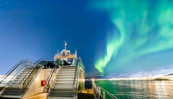 Cruise ship under Northern Lights in Tromso, Norway.