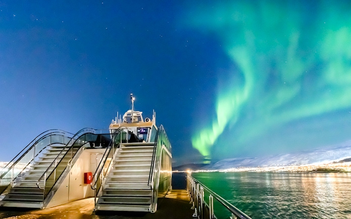 Cruise ship under Northern Lights in Tromso, Norway.