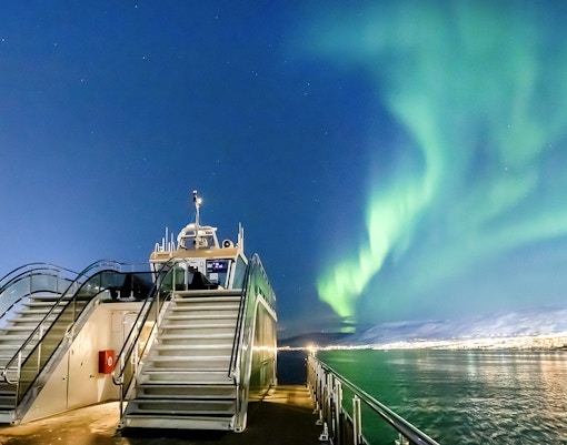 Cruise ship under Northern Lights in Tromso, Norway.