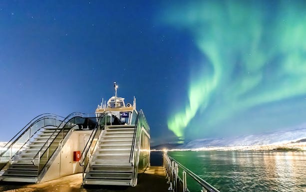 Cruise ship under Northern Lights in Tromso, Norway.