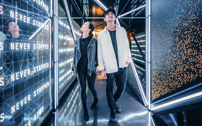 Visitors walking through a futuristic corridor at Edge, New York City.