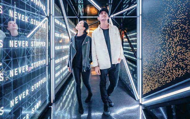 Visitors walking through a futuristic corridor at Edge, New York City.