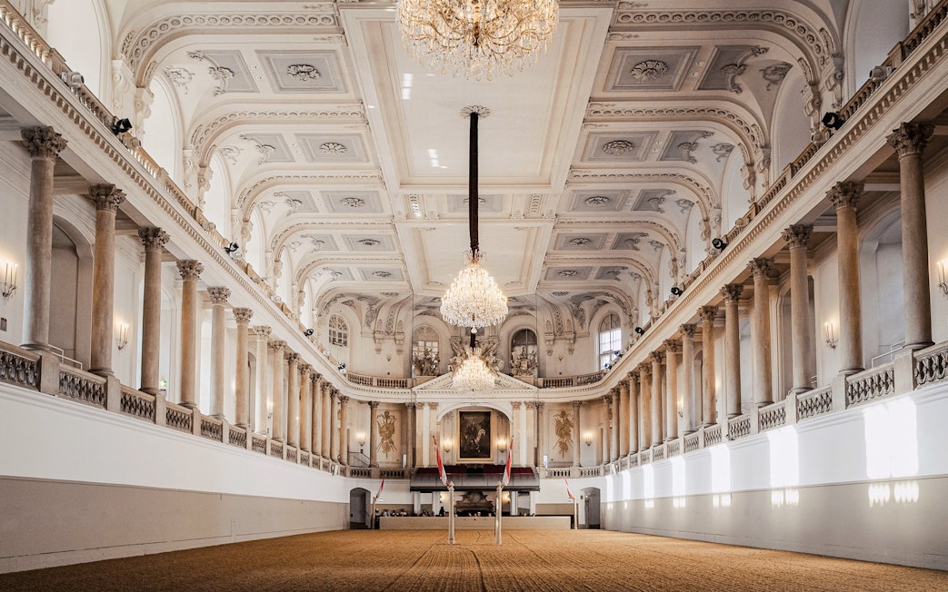 Spanish Riding School arena interior, Vienna, with chandeliers and ornate architecture.