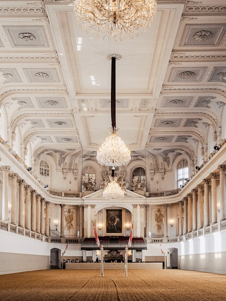 Spanish Riding School arena interior, Vienna, with chandeliers and ornate architecture.