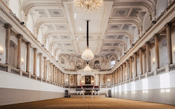 Spanish Riding School arena interior, Vienna, with chandeliers and ornate architecture.