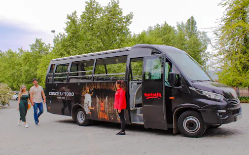 Transfer bus to Concha y Toro Winery in Santiago with passengers boarding.