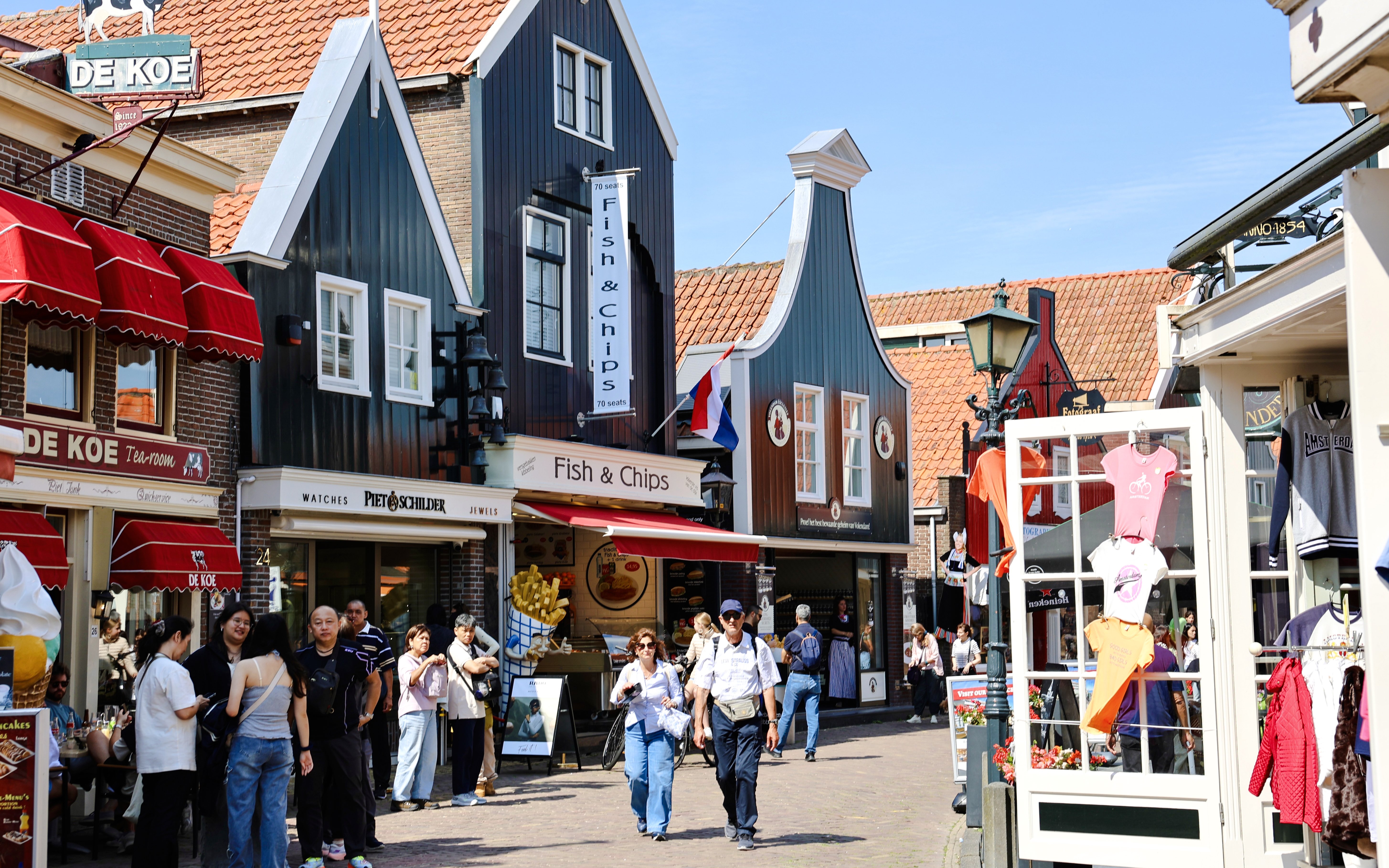 Street scene in Volendam, Netherlands, with shops and people walking.