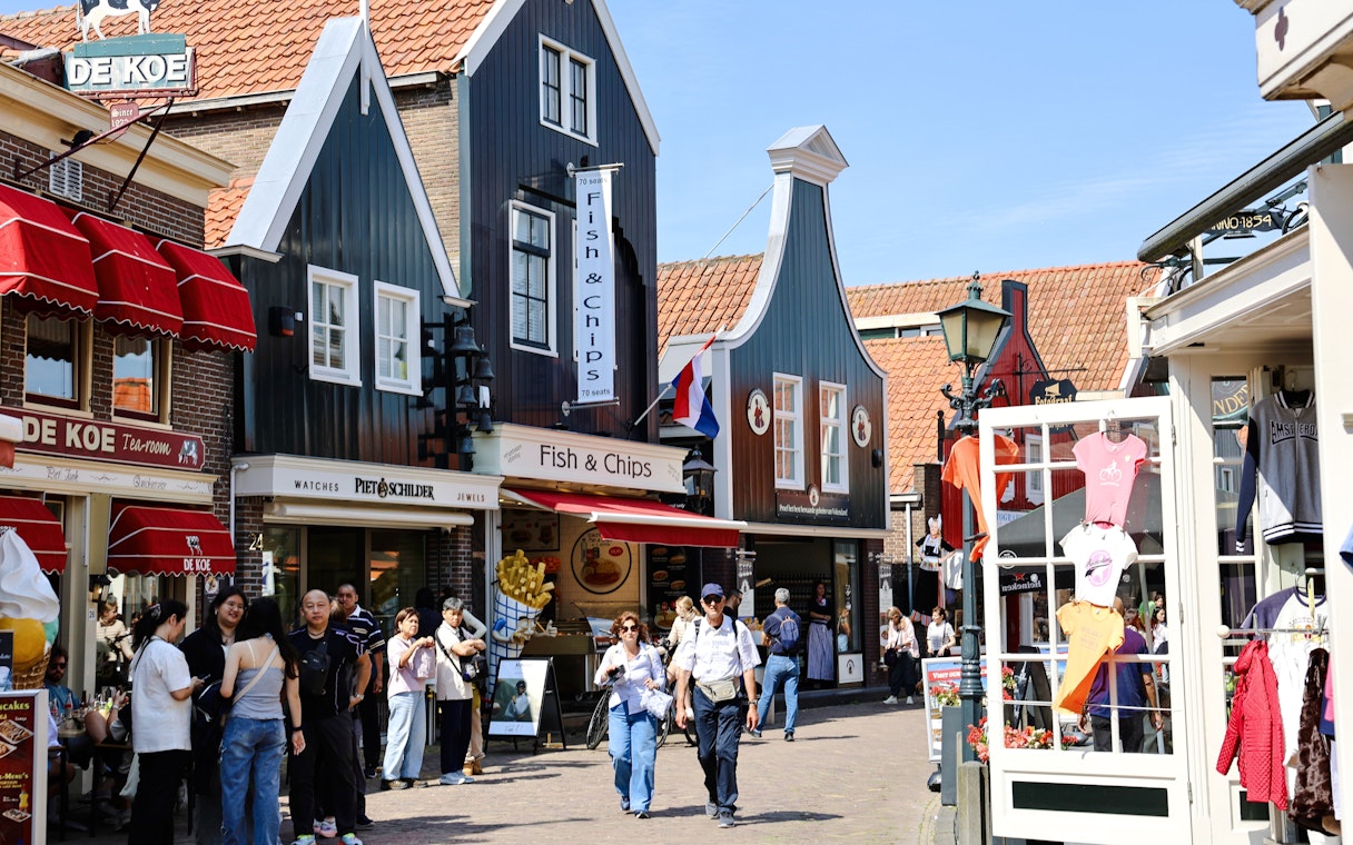 Street scene in Volendam, Netherlands, with shops and people walking.