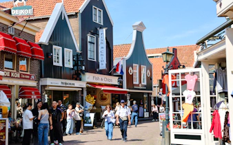 Street scene in Volendam, Netherlands, with shops and people walking.