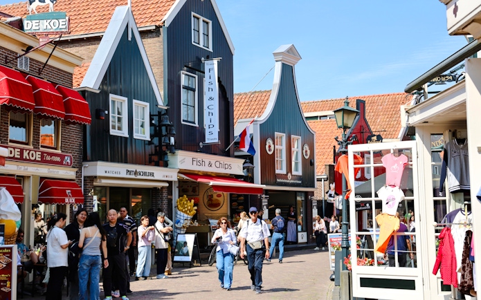 Street scene in Volendam, Netherlands, with shops and people walking.
