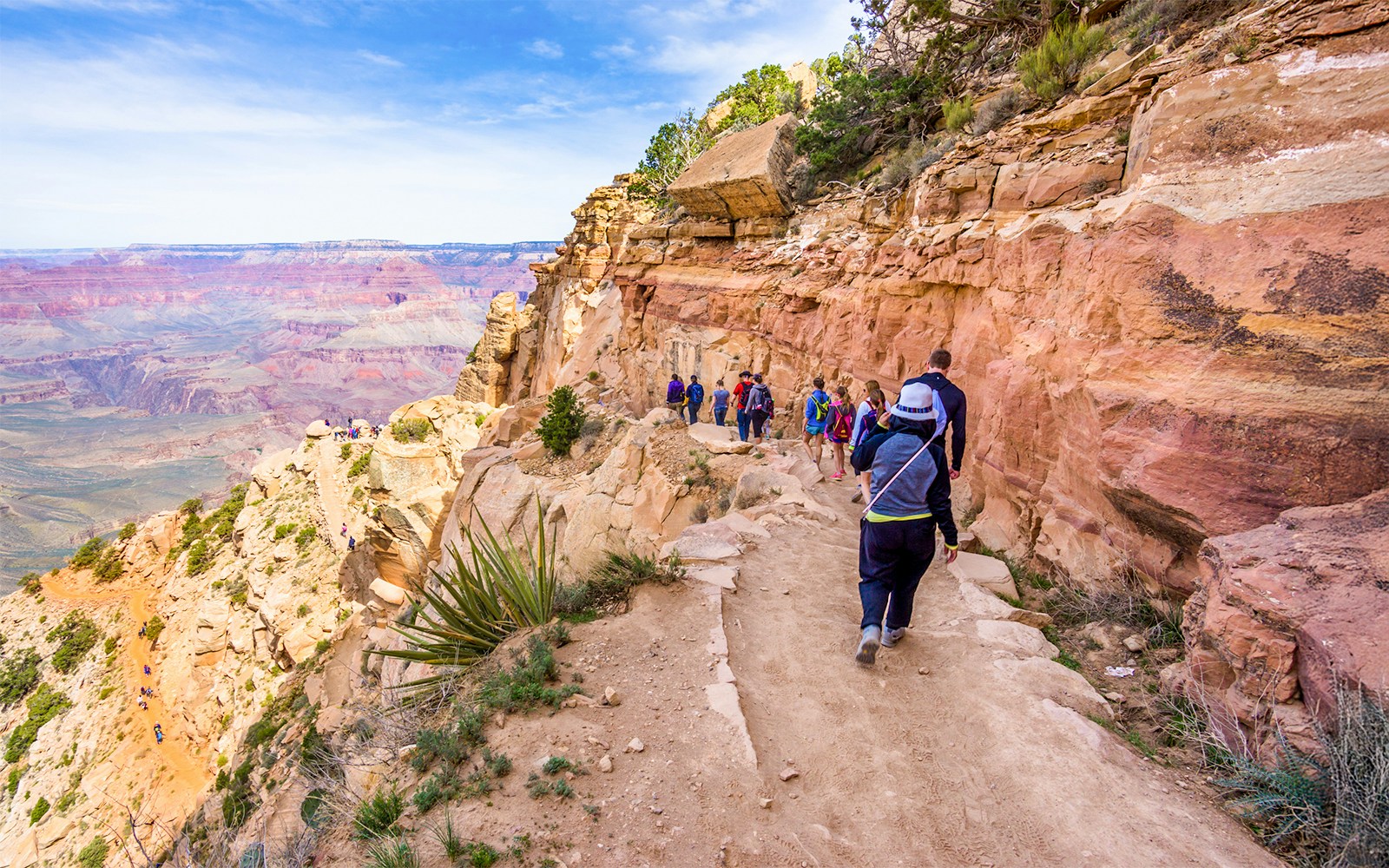 Guests walking along a trail with a view of the Grand Canyon West, Arizona.