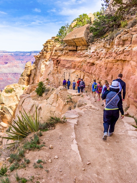 Guests walking along a trail with a view of the Grand Canyon West, Arizona.