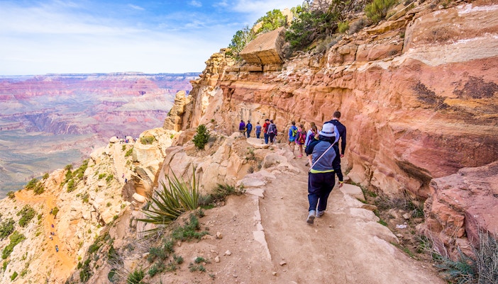 Guests walking along a trail with a view of the Grand Canyon West, Arizona.