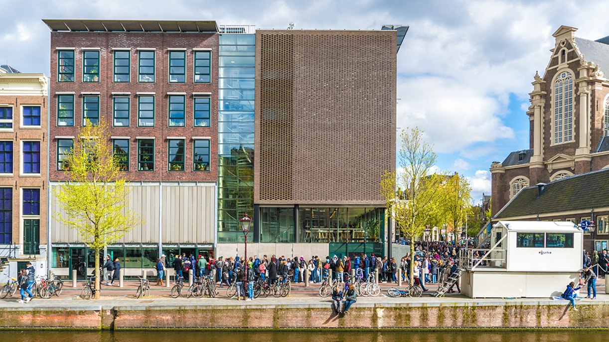 Anne Frank House in Amsterdam with visitors lining up outside.